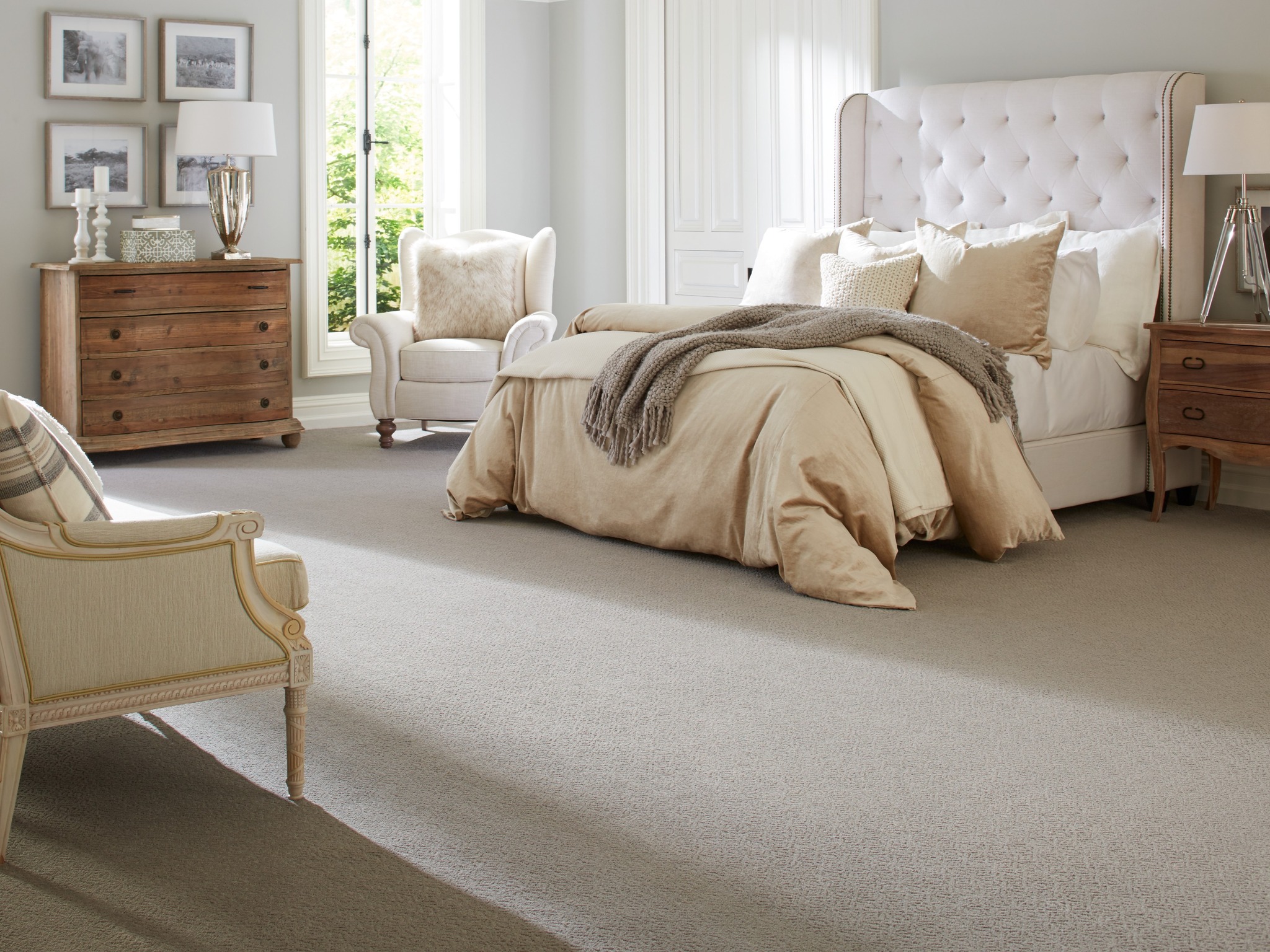 Large cream colored bedroom with carpet flooring